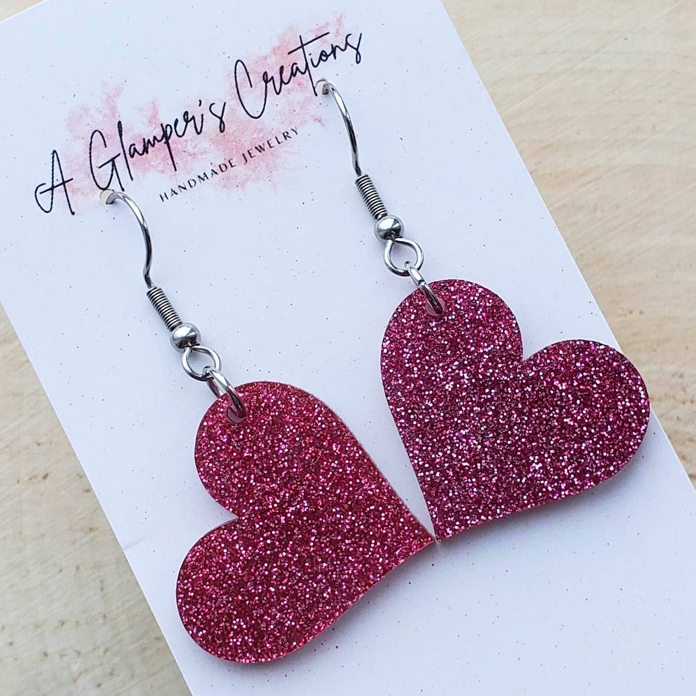 Heart shaped earrings made out of fuchsia glitter acrylic.