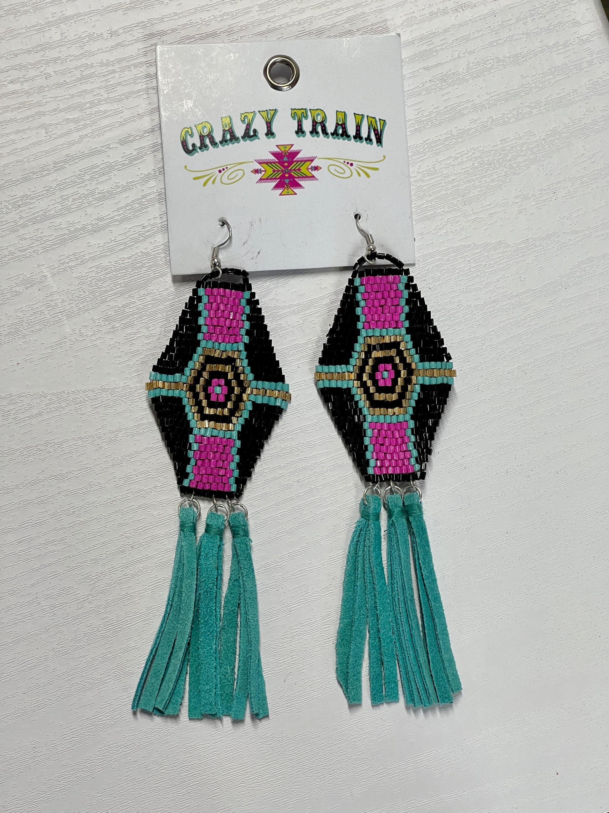 Crazy Train brand earrings.  Eloganted hexagon featuring a pattern with hot pink, teal black, and gold beads.  Adorned with 3 groups of teal leather tassels hanging from the bottom.