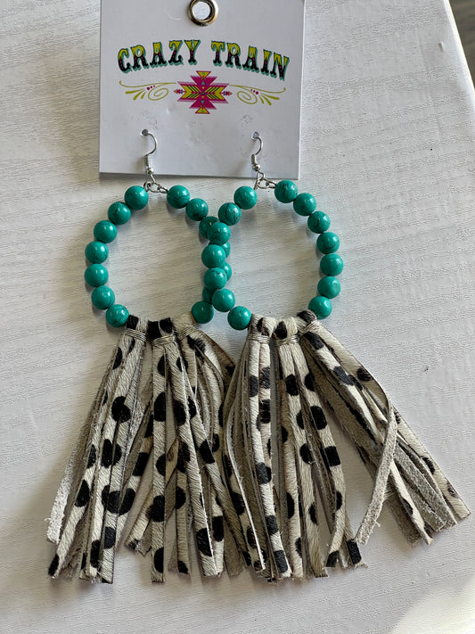 Crazy Train brand earrings.  Oval shape lined with teal beads.  Brown and cream cowhide printed leather tassels hang off bottom.
